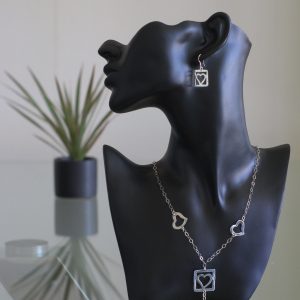 Ross: kombination av halsband, berlock och örhängen. Glansig sterling silver med ringar, rutor och hjärter